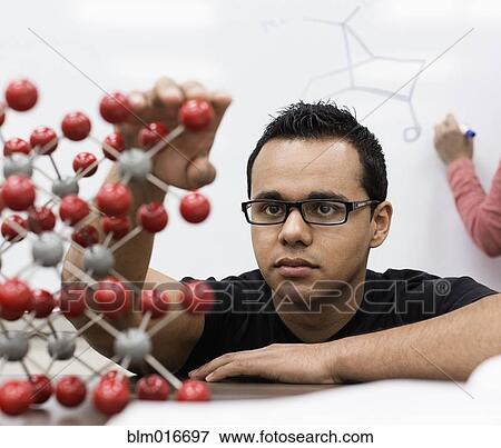 Stock Photo - Hispanic student examining molecular model. Fotosearch