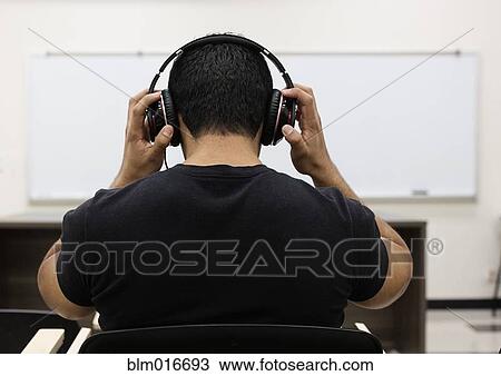Hispanic student listening to headphones in classroom View Large Photo Image Stock Image - Hispanic student listening to headphones in classroom. Fotosearch