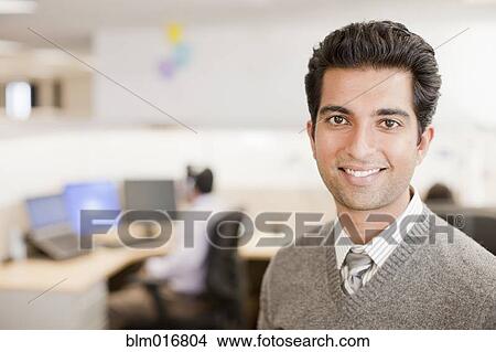 Picture - Indian businessman standing in office. Fotosearch