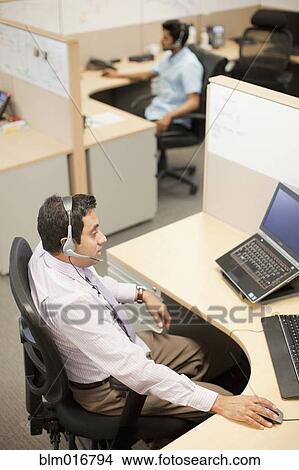 Picture - Indian businessman talking on headset. Fotosearch