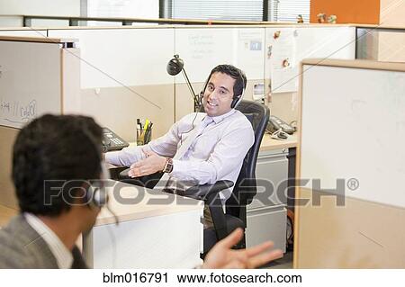 Stock Image - Indian businessmen talking between cubicles. Fotosearch