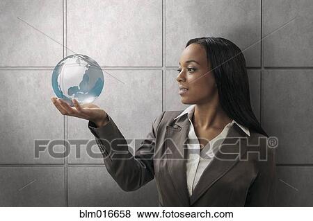 Stock Photo - Mixed race businesswoman holding globe. Fotosearch