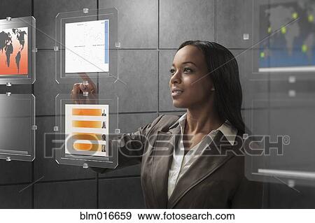 Stock Photo - Mixed race businesswoman using touchscreen. Fotosearch