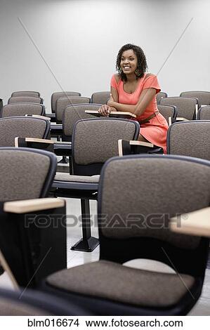 Mixed race student sitting in empty classroom View Large Photo Image Picture - Mixed race student sitting in empty classroom. Fotosearch
