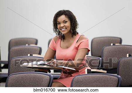 Mixed race student working in empty classroom View Large Photo Image Stock Image - Mixed race student working in empty classroom. Fotosearch