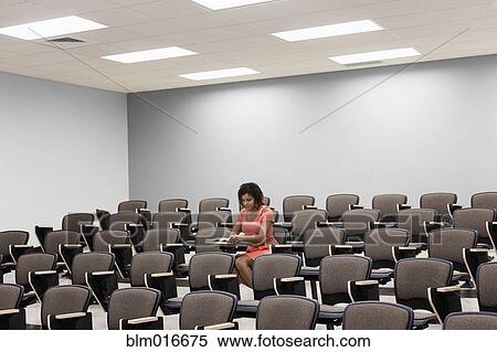 Mixed race student working in empty classroom View Large Photo Image Stock Photography - Mixed race student working in empty classroom. Fotosearch