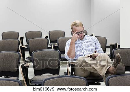 Stock Photo - Student reading in empty classroom. Fotosearch