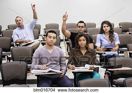 Picture - Students raising hands in classroom. Fotosearch