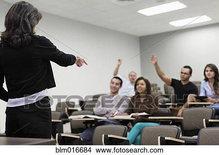 Picture - Teacher calling on students in classroom. Fotosearch