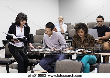 Stock Image - Teacher working with student in classroom. Fotosearch