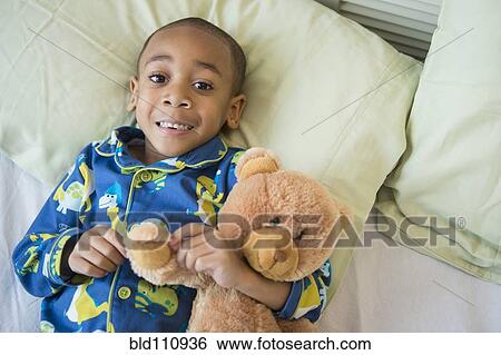 African American boy hugging teddy bear in bed View Large Photo Image Stock Photograph - African American boy hugging teddy bear in bed. Fotosearch