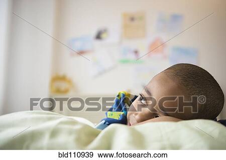 African American boy laying in bed View Large Photo Image Stock Photo - African American boy laying in bed. Fotosearch