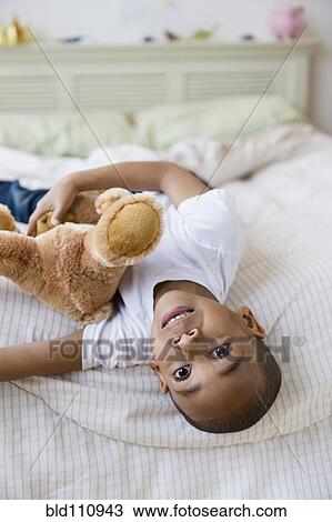 African American boy laying on bed View Large Photo Image Stock Image - African American boy laying on bed. Fotosearch