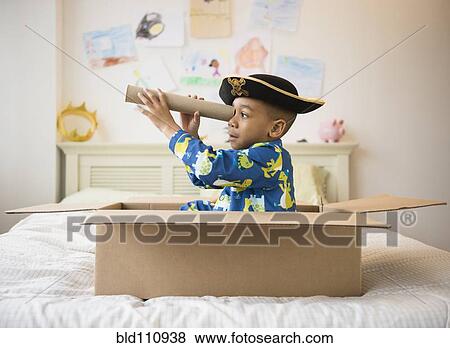 Stock Photo - African American boy playing in cardboard box. Fotosearch