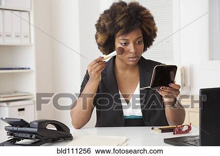 African American businesswoman applying makeup in office View Large Photo Image Stock Photograph - African American businesswoman applying makeup in office. Fotosearch