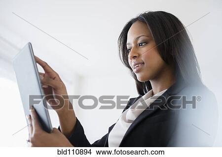 Picture - African American businesswoman using tablet computer. Fotosearch