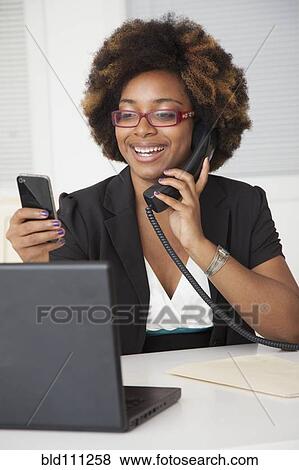 Stock Photo - African American businesswoman working at desk. Fotosearch