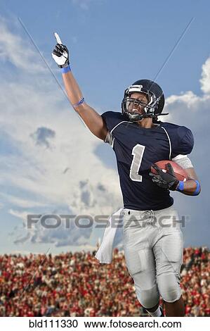 Stock Image - African American football player cheering in game. Fotosearch