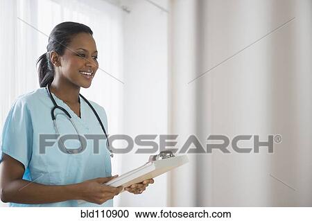 Stock Image - African American nurse holding clipboard. Fotosearch