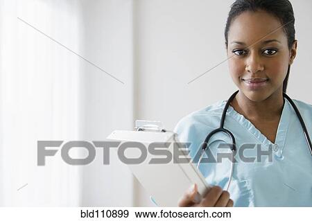 Stock Photo - African American nurse holding clipboard. Fotosearch