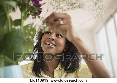 Stock Photo - African American woman arranging flowers. Fotosearch