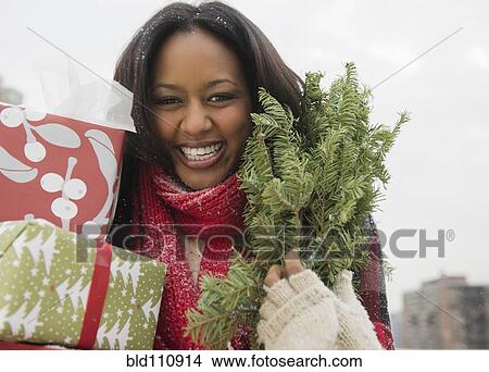 African American woman carrying Christmas presents View Large Photo Image Picture - African American woman carrying Christmas presents. Fotosearch