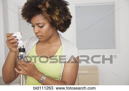 African American woman examining light bulb View Large Photo Image Stock Image - African American woman examining light bulb. Fotosearch