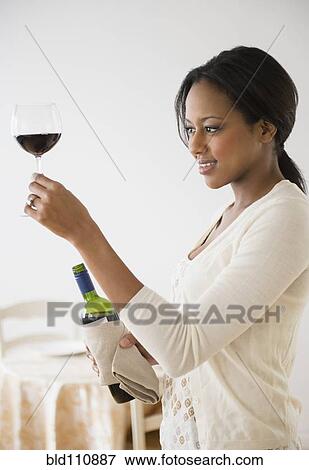 Stock Photo - African American woman having glass of wine. Fotosearch