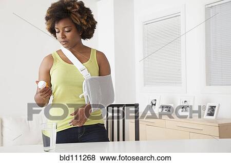 African American woman in sling taking medication View Large Photo Image Stock Photo - African American woman in sling taking medication. Fotosearch
