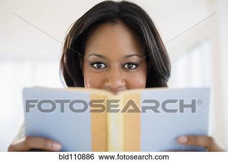 Stock Photograph - African American woman reading book. Fotosearch