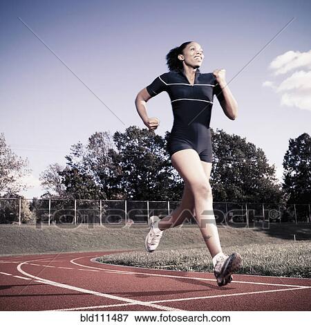 Stock Photo - African American woman running on track. Fotosearch
