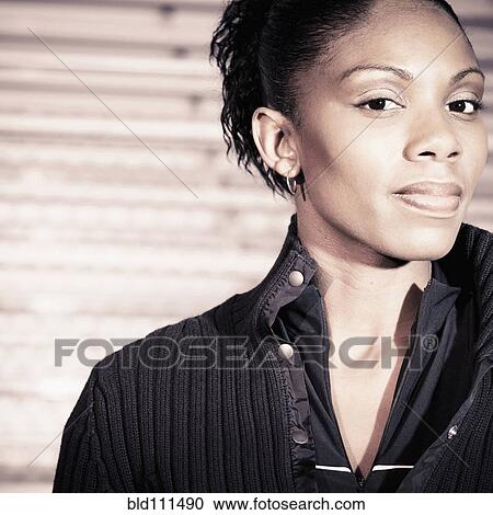 Stock Image - African American woman standing by bleachers. Fotosearch