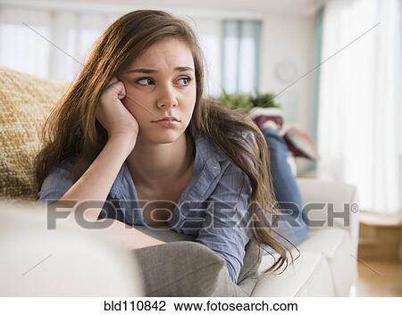 Anxious Hispanic girl laying on sofa View Large Photo Image Stock Image - Anxious Hispanic girl laying on sofa. Fotosearch