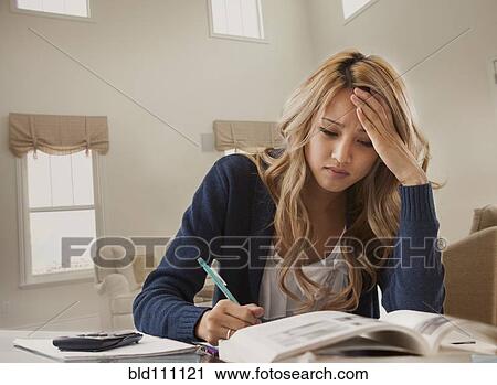 Stock Image - Anxious mixed race woman studying. Fotosearch