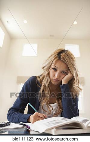 Stock Image - Anxious mixed race woman studying. Fotosearch