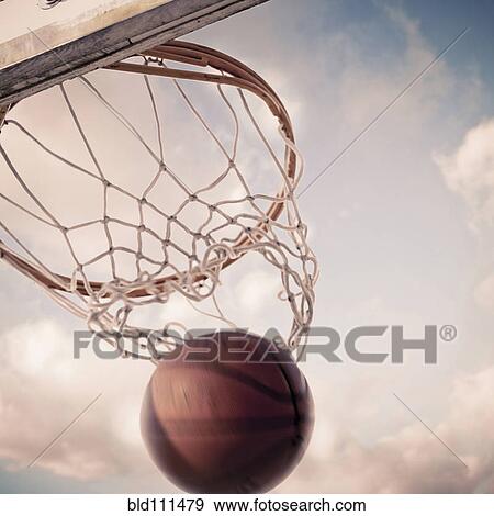 Basketball falling through hoop on court View Large Photo Image Stock Photo - Basketball falling through hoop on court. Fotosearch