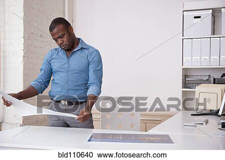 Black architect looking at blueprints in office View Large Photo Image Stock Image - Black architect looking at blueprints in office. Fotosearch