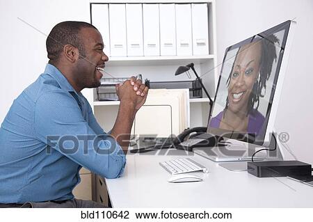 Black businessman talking to co-worker over computer View Large Photo Image Stock Image - Black businessman talking to co-worker over computer. Fotosearch