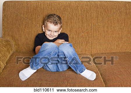 Caucasian boy sitting on sofa View Large Photo Image Stock Image - Caucasian boy sitting on sofa. Fotosearch