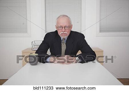 Caucasian businessman frowning at table View Large Photo Image Stock Image - Caucasian businessman frowning at table. Fotosearch