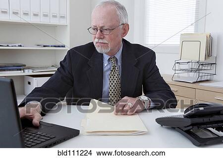 Picture - Caucasian businessman working in office. Fotosearch