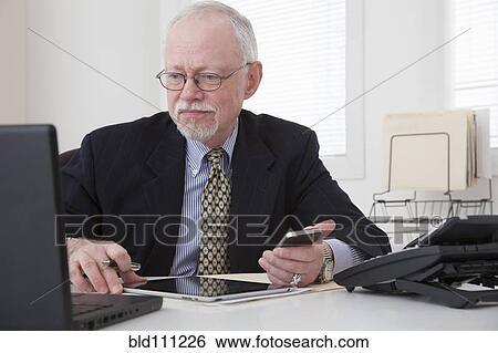 Stock Photograph - Caucasian businessman working in office. Fotosearch