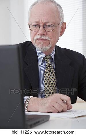 Stock Photography - Caucasian businessman working on laptop. Fotosearch
