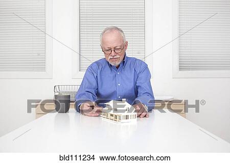 Caucasian businessman working on model of house View Large Photo Image Picture - Caucasian businessman working on model of house. Fotosearch