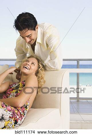 Caucasian couple laughing in living room View Large Photo Image Picture - Caucasian couple laughing in living room. Fotosearch