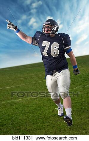 Stock Image - Caucasian football player cheering in game. Fotosearch