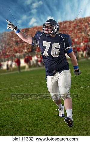 Stock Image - Caucasian football player cheering in game. Fotosearch