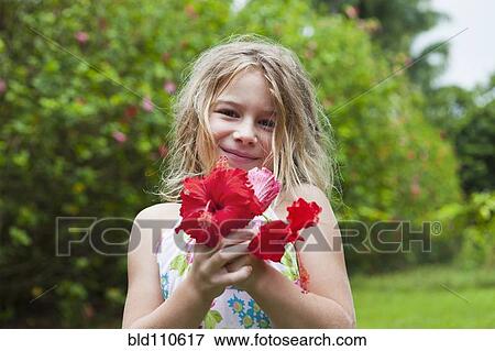 Caucasian girl holding red flowers View Large Photo Image Stock Photo - Caucasian girl holding red flowers. Fotosearch