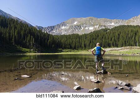 Caucasian hiker standing on rocks in lake View Large Photo Image Picture - Caucasian hiker standing on rocks in lake. Fotosearch