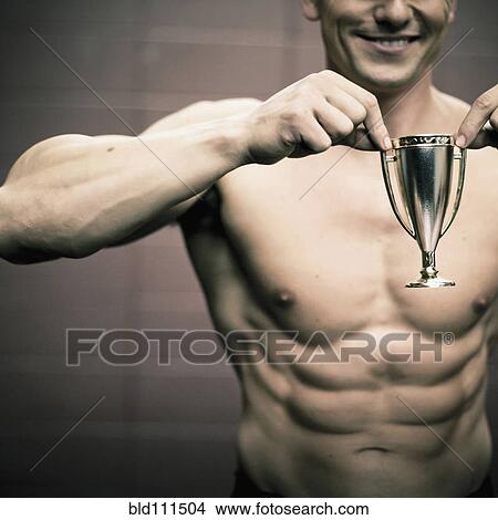 Picture - Caucasian man holding small trophy. Fotosearch